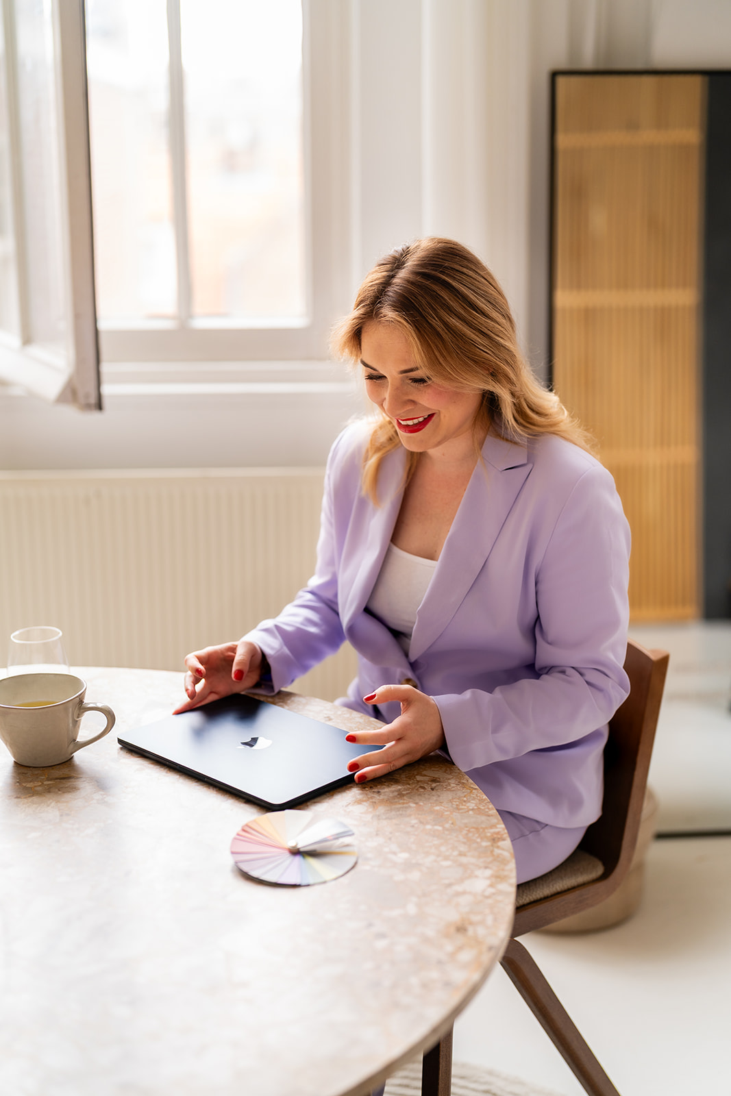 Marly aan tafel met haar laptop en kleurenwaaier tijdens een kleuranalyse